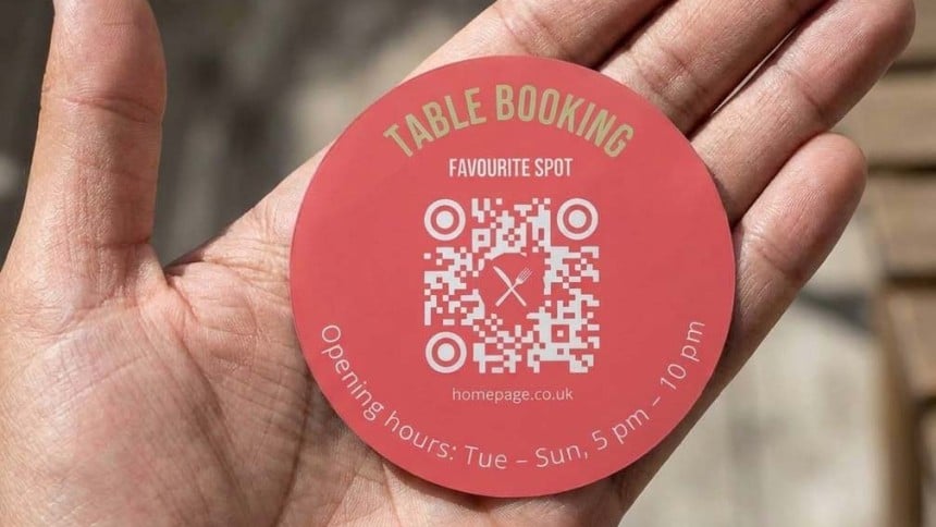 Hand holding a 100mm round QR Code sticker