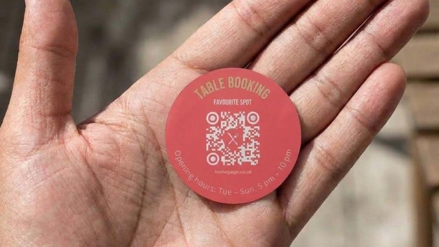 Hand holding a 40mm round qr code sticker
