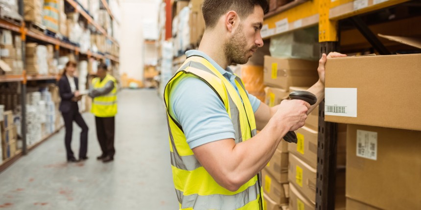 Man in high vis jacket scanning a barcode in a large warehouse