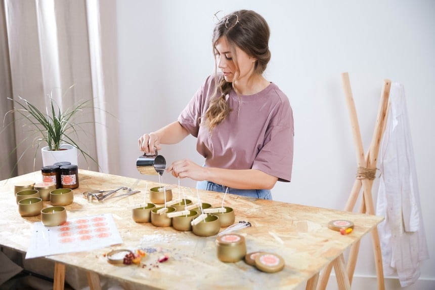 Woman entrepreneur pouring candles at a table