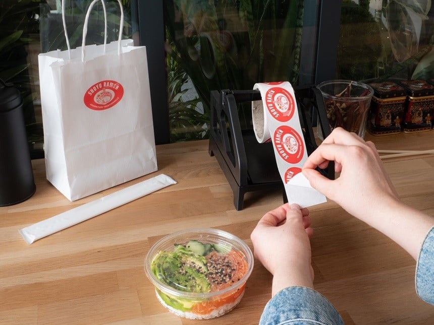 Hand applied roll labels using a dispenser