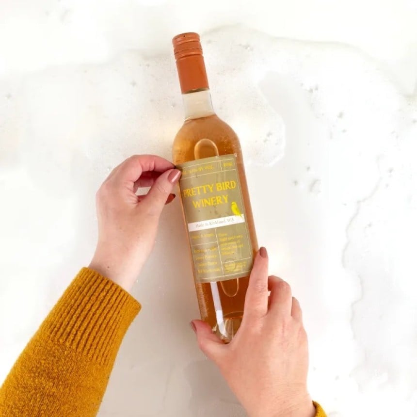 Peeling label off wine bottle