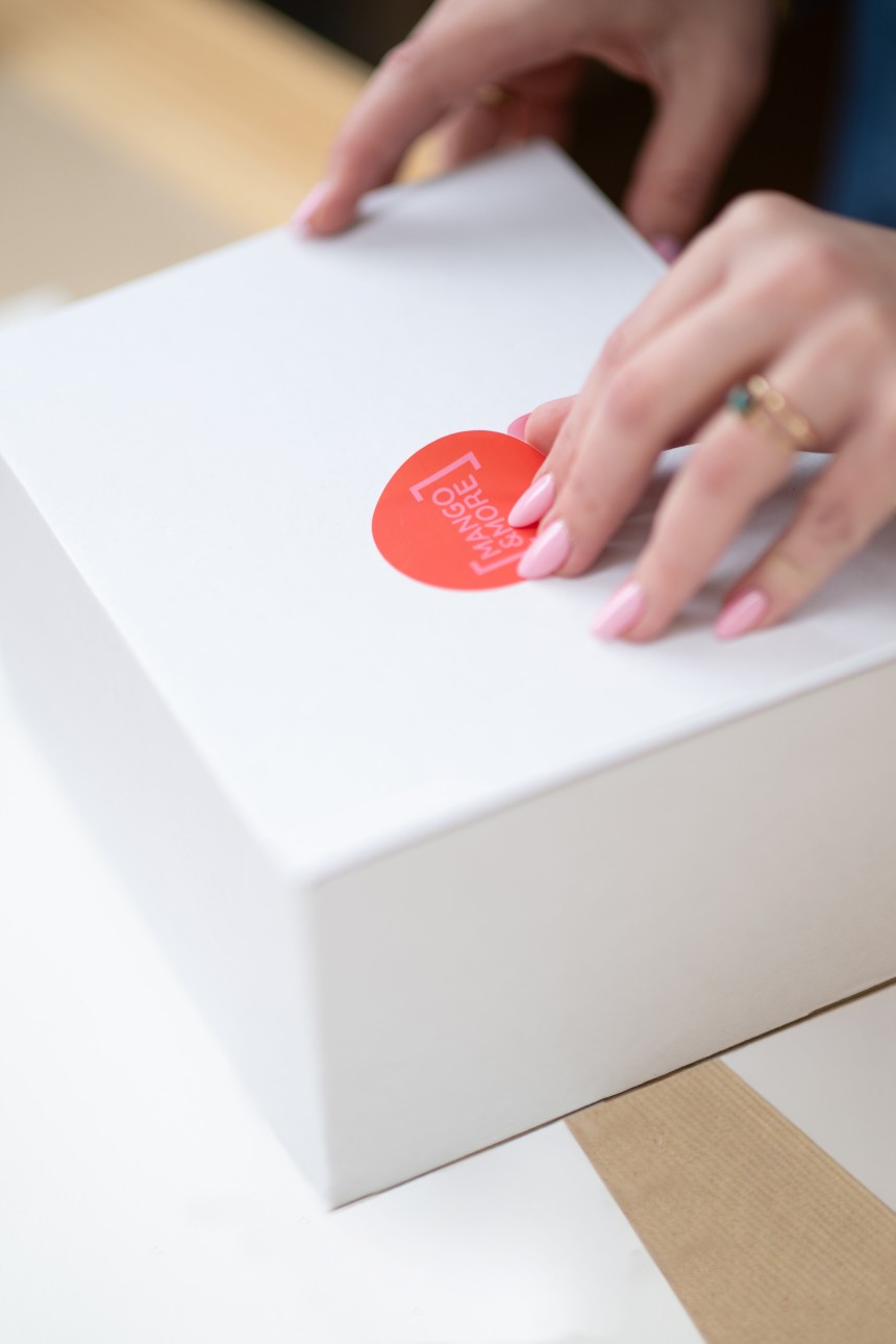 Woman sticks round label on parcel.