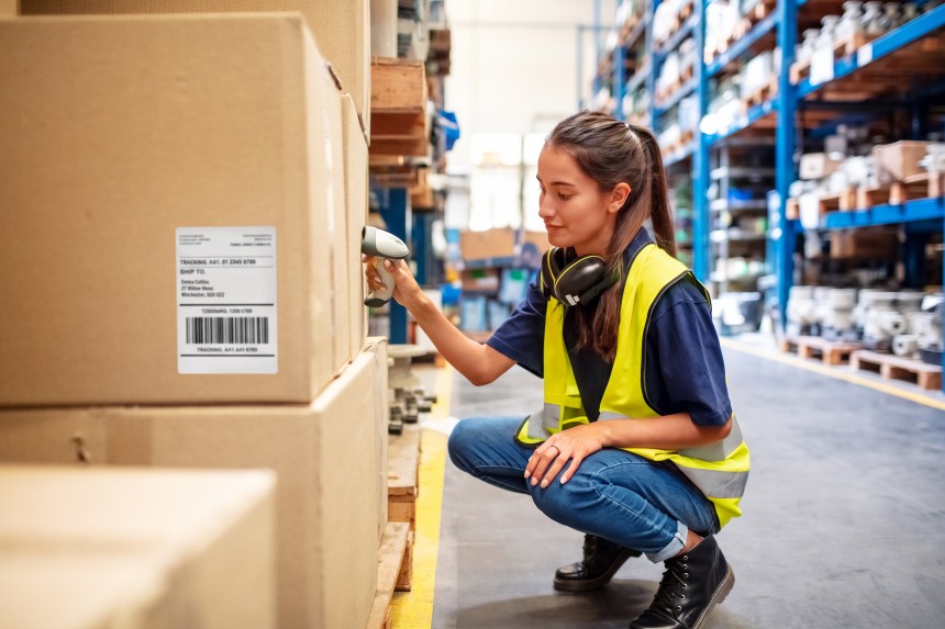 woman reviewing boxes in warehouse