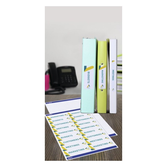 The image displays three binders labeled 'Budgets,' 'Marketing,' and 'Meetings' arranged on a wooden desk. In front of them, there's a sheet of labels featuring the same titles along with 'Customers.' A black telephone is visible in the background.