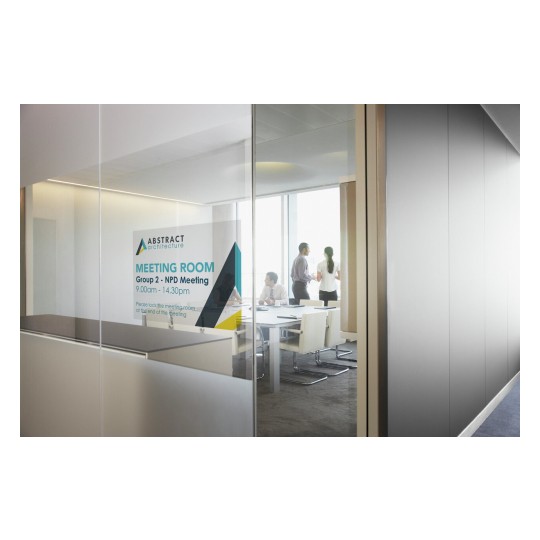 The image shows a meeting room with a sign indicating 'Group 2 - NPD Meeting' scheduled from 9:00 AM to 2:30 PM. Through the glass, people are engaging in conversation inside the room by a large table.