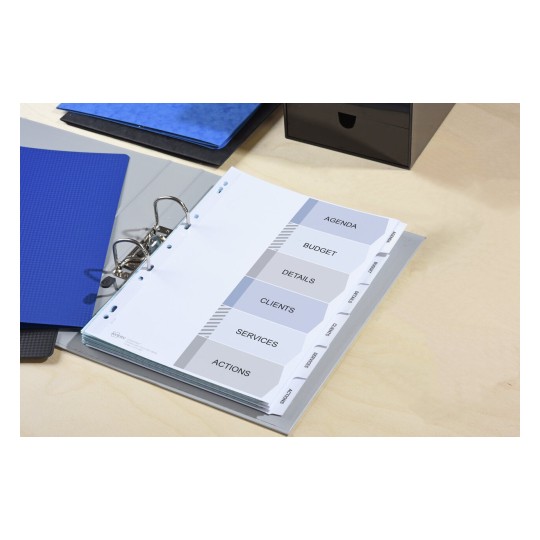 An organized binder with tabs labeled for agenda, budget, details, clients, services, and actions. The binder is on a wooden surface alongside blue and black folders.