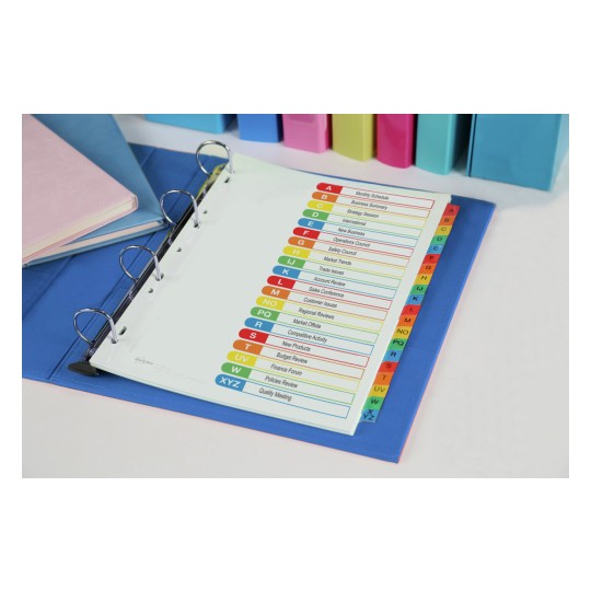 The image shows a binder with a color-coded index sheet listing various topics such as business summaries, market trends, and sales conferences. The binder is on a blue folder, with additional colored binders in the background, including green, pink, and blue.
