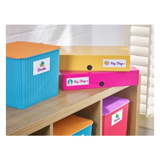 The image shows colorful storage boxes labeled with various categories such as 'Bricks', 'Key Stage 1', 'Key Stage 2', and 'Puzzles' on a wooden shelf, with a bright and organized aesthetic.