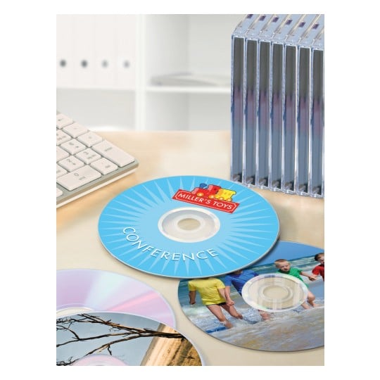 The image shows several CDs on a desk, with a keyboard and a stack of CD cases in the background. One of the CDs has the 'Miller's Toys' logo and the text 'CONFERENCE'.