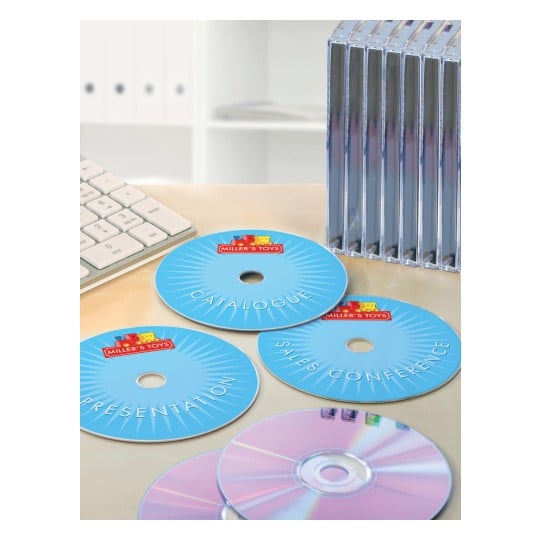 The image shows a keyboard, various CDs with the logo of Miller's Toys, including CDs for a catalog, presentation, and sales conference, and a stack of empty CD cases.