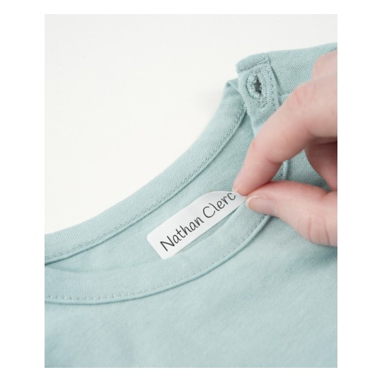 The image shows a hand holding a label that reads 'Nathan Clerc' inside the collar of a light green garment.