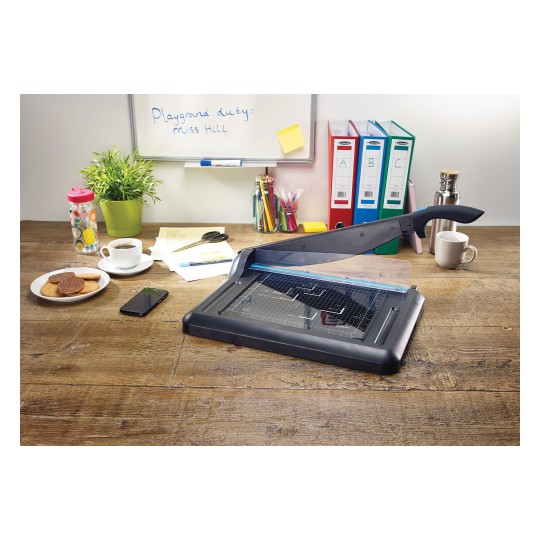 The illustration shows a desk with a letter opener, a cup of coffee, a plate of cookies, a phone, and well-organized documents. There is also a potted plant and a whiteboard with annotations.