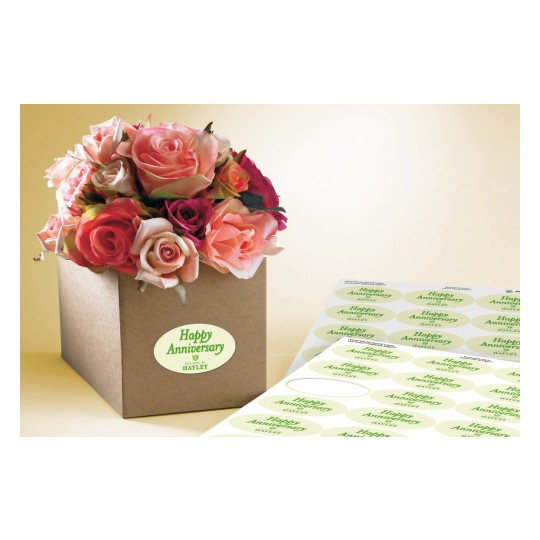 The image features a box of flowers containing various shades of roses, with an anniversary label on the box and additional labels nearby.