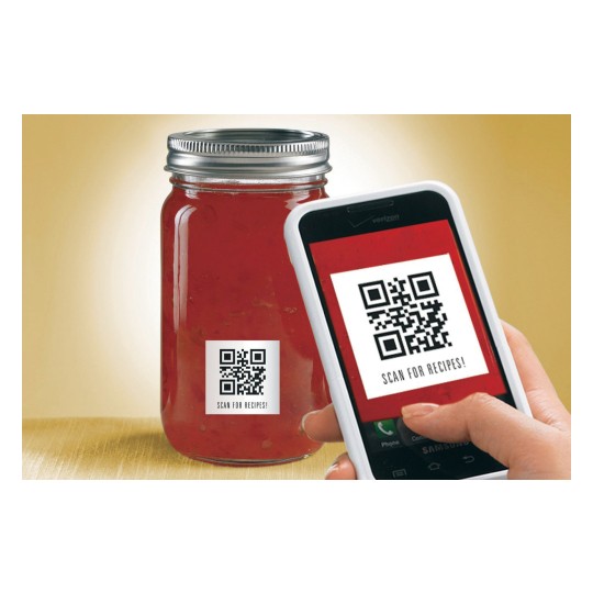 In the image, there is a jar with a label that has a QR code. Next to it, there is a mobile phone pointing at the label with the instruction 'Scan for recipes.'