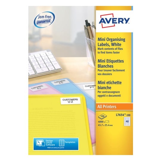 The image shows mini organizational labels from the brand Avery, along with a keyboard and pens in a holder. The labels are white and are intended for marking files.