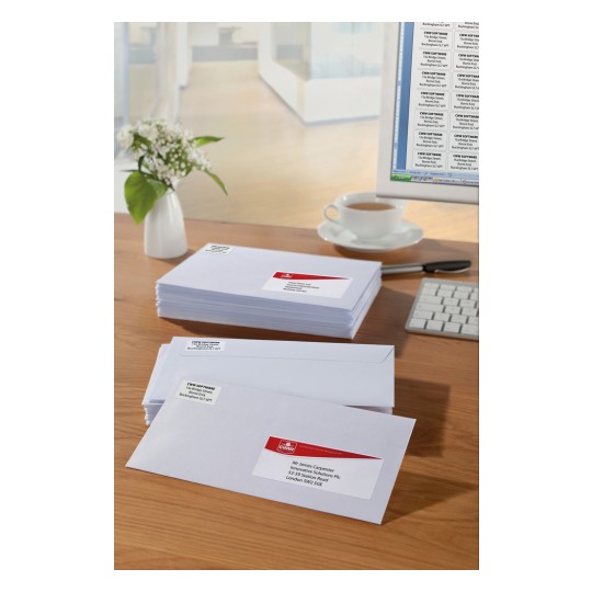 The image shows several unopened envelopes with addresses on the front, and a computer with a word processor. Next to them, there is a cup of coffee and a vase with flowers on a desk.