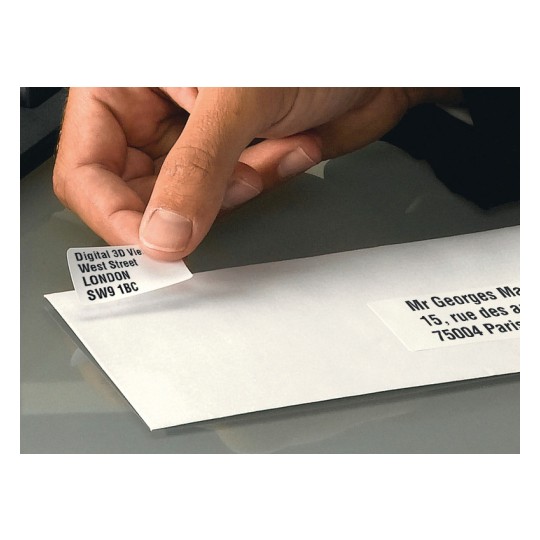 A hand removing a label with address information from an envelope. The label contains information about London, England, and the other part has an address in Paris, France.