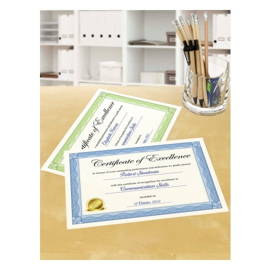 The image displays two certificates of excellence on a table. One certificate is green and the other is blue, both recognizing someone for their communication skills, awarded on October 12, 2012. There is also a glass container filled with pencils and pens next to the certificates.
