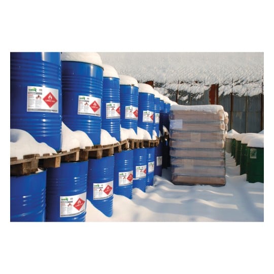 The image shows blue barrels containing hazardous substances in a snowy environment, with stacks of wooden pallets and some green barrels in the background.