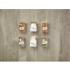 The image features six glass jars filled with various ingredients. They are labeled as Coffee, Salt, Pepper, and Flour. The jars are arranged in two rows on a textured surface.