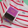 The image features a clothing stamp labeled 'Clothing Stamp' on a striped shirt. The shirt has red and white horizontal stripes and displays a tag with the name 'LAURA BAYARD.' The background is a solid color.