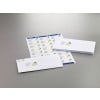 The image shows several envelopes and a sheet with printed labels. The envelopes have a logo on them, and the labels are formatted for address use, featuring the same logo. They are placed on a neutral-colored surface.