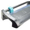 The image shows a cutting tool, specifically a guillotine paper cutter, featuring a clear cutting line guide and measurement grid on the surface.
