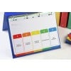 The image shows a binder with a visible sheet containing five colored tabs labeled: Monthly Schedule, Business Summary, Strategy Session, International, and New Business.