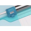 The image features a blue cutting tool, likely a paper cutter or trimmer, positioned over a light blue background. The tool includes a level gauge and a ruler, suggesting it is used for precise cutting or measuring, possibly for crafting or office use.
