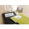 The image features a notepad labeled 'Take Notes', a green 'Programme' notebook, a pen, a glass of water, and a small package labeled 'with compliments', all arranged on a wooden surface, indicating a training event.
