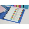 The image shows a binder with a color-coded index sheet listing various topics such as business summaries, market trends, and sales conferences. The binder is on a blue folder, with additional colored binders in the background, including green, pink, and blue.