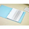 The image shows a neatly organized binder with tabs labeled 'Company Clients' arranged alphabetically. The binder has a blue cover and is placed on a wooden desk next to a computer keyboard.