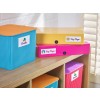 The image shows colorful storage boxes labeled with various categories such as 'Bricks', 'Key Stage 1', 'Key Stage 2', and 'Puzzles' on a wooden shelf, with a bright and organized aesthetic.