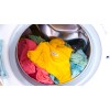 The image shows a washing machine full of clothes in various colors, including a yellow t-shirt and other garments in pink and light blue tones, spinning inside the drum.