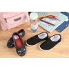 In the image, there is a pair of shoes, a pink case, a water bottle, notebooks, and pencils on a wooden table.