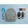 The image shows a green polka dot backpack, a blue pencil sharpener, glasses, an eraser, paperclips, colored pencils, and a figure of a shoe with a smiling face.