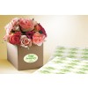 The image features a box of flowers containing various shades of roses, with an anniversary label on the box and additional labels nearby.