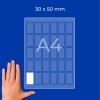 Hand beside an A4 sheet showing a 30 x 50 mm grid of label rectangles