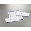 The image shows a stack of white envelopes with a logo and address labels on them, all presented on a gray background.
