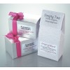 The image shows two gift boxes with luxury handmade truffles and a pack of loose tea. The boxes have a pink ribbon, while the tea organization is organic and locally selected.