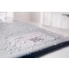 The image shows a wet folder or document with droplets of water on it. The label on the folder appears to contain personal information but is partially obscured by moisture. It suggests the item was exposed to water.