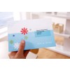 An invitation card held in a hand, featuring colorful floral designs and the text 'You're invited.' The card has an address label for Spencer Design Studios in Edinburgh.