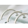 The image shows a close-up of metal rings from a binder holding white sheets of paper together, with a soft focus background.