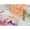 The image shows a colorful box with a floral pattern and a label with the name 'Anne Miller'. Next to it, there is a picture with the text 'prio A' and a computer keyboard in the background.