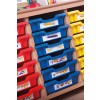 The image shows a wooden storage unit with colored bins, specifically red, blue, and yellow, containing labeled supplies such as pencils, pens, and art tools.