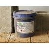 The image shows a blue bucket labeled 'Polyurethane Coating' with warning symbols, placed on a wooden surface near concrete blocks, indicating it may contain hazardous materials.